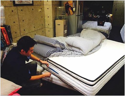 老闆在門市整理展示床墊