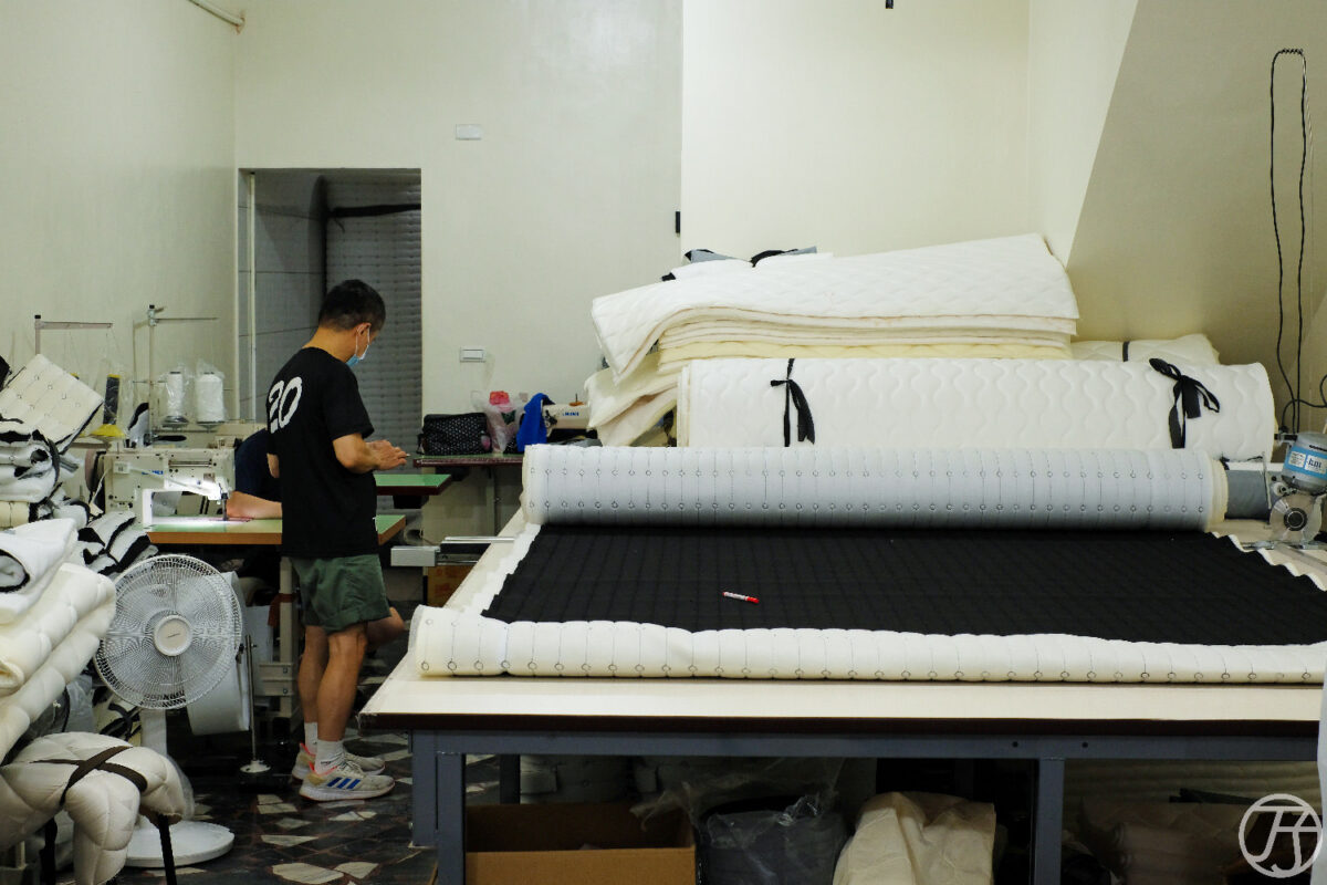 工廠師傅在工作台上處理床墊表布