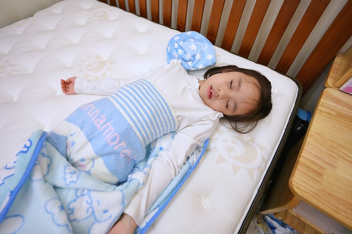 小女孩仰睡在曙光床墊上